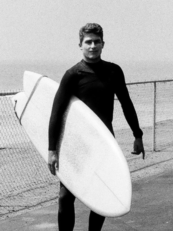 Bryce Kolb with his surfboard on the coast